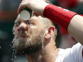 Washington Nationals' Bryce Harper dumps water on his face in the dugout before the first baseball game of a doubleheader against the Atlanta Braves at Nationals Park, Tuesday, Aug. 7, 2018, in Washington. Temperatures were in the 90's at the start of the game.