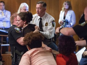 Protester Ashley Popio is removed from a N.C. Historical Commission meeting at the N.C. State Archives in Raleigh after she made an outburst while commission members were making recommendations on what to do with three Confederate monuments at the N.C. State Capitol grounds, Wednesday, Aug. 22, 2018.