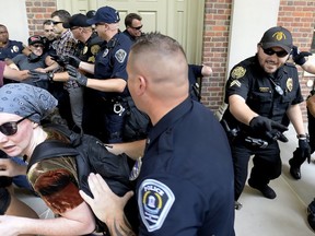 Protesters scuffle with police during a rally in front of Graham Memorial Building on the campus of UNC in Chapel Hill, N.C., Saturday, Aug.25, 2018. The rally featured those for and against the removal of the controversial "Silent Sam" statue which was toppled earlier this week.