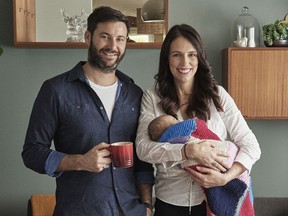 New Zealand Prime Minister Jacinda Ardern, right, poses for a family portrait with partner Clarke Gayford and their baby daughter Neve in their home in Auckland, New Zealand.