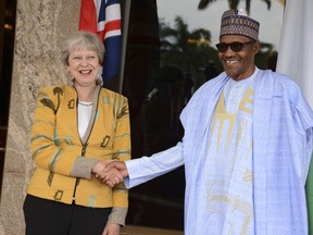 British Prime Minister Theresa May, left, is welcomed by Nigeria's President Muhammadu Buhari, at the Presidential palace in Abuja, Nigeria, Wednesday, Aug 29, 2018. Britain and Nigeria have signed a security and defense agreement during a one-day visit by Prime Minister Theresa May as Africa's most populous country struggles to defeat Boko Haram extremists and others linked to the Islamic State organization.