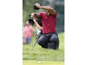 Tiger Woods wipes himself as he waits to play on the fourth hole during the final round of the Northern Trust golf tournament, Sunday, Aug. 26, 2018, in Paramus, N.J.