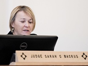 In this Monday, Aug. 13, 2018 photo, District Court Judge Sarah C. Backus presides over the hearing in the Amalia, N.M., desert compound case in Taos, N.M. Backus cleared the way for the release of two men and three women under conditions of house arrest including ankle monitors, despite assertions by prosecutors that the group was training children to use firearms for an anti-government mission and should remain in jail pending trial. Backus' decision to allow the release of an extended family accused of child abuse at a ramshackle desert compound set off a political uproar.