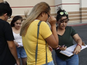 In this Aug. 15, 2018, photo, Maria Nieto, right, and Alma Romo, second from left, register people to vote in Las Vegas. Democrats in Nevada are working to register and engage Latino voters ahead of this year's midterms, hoping to recreate the big wins that the state's Hispanic and immigrant community are credited with delivering two years ago.