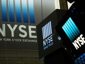 FILE- In this May 10, 2018, file photo signs for the New York Stock Exchange hang above the trading floor.  U.S. stocks are rising at the opening bell, Wednesday, Aug. 1, 2018,  as Apple surges following a strong quarterly report. Banks are jumping as a strong jobs report sends interest rates higher.