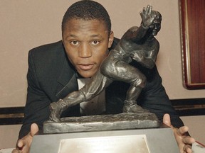 FILE - In this Dec. 8, 1988, file photo, Oklahoma State's running back Barry Sanders poses with his Heisman Trophy at New York's Marriott Marquis Hotel. His rare combination of exceptional power, speed and elusiveness helped him run for at least two touchdowns in every game that season and at least four on seven occasions.