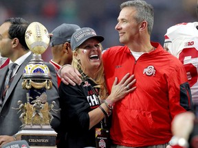 FILE - In this Jan. 1, 2016, file photo, Ohio State head coach Urban Meyer hugs his wife, Shelley, after their 44-28 win over Notre Dame in the Fiesta Bowl NCAA college football game, in Glendale, Ariz. Ohio State placed Meyer on paid administrative leave Wednesday, Aug. 1, 2018, while it investigates claims that his wife knew about allegations of abuse against former Buckeyes assistant Zach Smith, who was fired last week.
