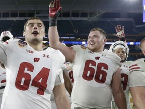 FILE - In this Dec. 30, 2017, file photo, Wisconsin offensive linemen Brett Connors (64) and Beau Benzschawel (66) celebrate at the end of the Orange Bowl NCAA college football game against Miami, in Miami Gardens, Fla. Benzschawel was selected to the AP Preseason All-America team, Tuesday, Aug. 21, 2018.