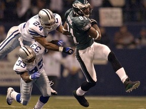 FILE - In this Nov. 15, 2004, file photo, Philadelphia Eagles wide receiver Terrell Owens (81) pulls in a 50-yard touchdown pass in front of Dallas Cowboys defenders Nathan Jones (33) and Tony Dixon (24) during the first quarter of an NFL football game in Irving, Texas. Owens is skipping his induction ceremony into the Pro Football Hall of Fame in Canton, Ohio on Saturday, Aug. 4, 2018, and instead giving his acceptance speech at the University of Tennessee at Chattanooga.