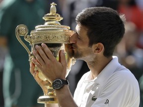 FILE - In this July 15, 2018, file photo, Serbia's Novak Djokovic holds the trophy after winning the men's singles final against Kevin Anderson, of South Africa, at the Wimbledon Tennis Championships in London. Djokovic is the men's No. 6 seed at this year's U.S. Open, which starts Monday.