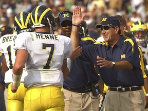 FILE - In this Sept. 16, 2006, file photo, Michigan coach Lloyd Carr, right, high fives quarterback Chad Henne after he threw a touchdown pass in the second quarter in college football action against Notre Dame in South Bend, Ind. Michigan has not won a true road game against a ranked team since winning at Notre Dame in 2006. The 14th-ranked Wolverines have a shot to stop the 0-16 streak when they open the season Saturday night against the 12th-ranked Fighting Irish.