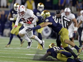 File- This Oct. 15, 2016, file photo shows Stanford wide receiver Trenton Irwin (2) leaping over Notre Dame safety Devin Studstill (14) as he's tackled by safety Drue Tranquill (23) during the first quarter of an NCAA college football game in South Bend, Ind. Notre Dame head football coach Brian Kelly thinks his players' familiarity with new defensive coordinator Clark Lea's defense will breed contempt for the opposition this fall. Tranquill, a rover last year, returns for his fifth season at weakside linebacker position.