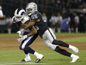 FILE - In this Saturday, Aug. 19, 2017 file photo, Oakland Raiders linebacker Marquel Lee (55) tackles Los Angeles Rams tight end Gerald Everett during the first half of an NFL preseason football game in Oakland, Calif. Marquel Lee wasn't quite ready to end the revolving door at middle linebacker for the Oakland Raiders when he was thrown into the starting lineup to start his rookie season last year. With a year of experience and a defensive scheme that better suits his game, Lee is doing his best to seize that role this season even after the Raiders brought in veteran Derrick Johnson to be the likely starter.