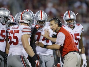 FILE - In this Sept. 17, 2016, file photo, Ohio State head coach Urban Meyer talks with his players in the fourth quarter of an NCAA college football game against Oklahoma, in Norman, Okla. Meyer's current suspension and previous paid leave have restricted him from talking football with his staff and athletes during August with one exception _ a team meeting the day after the suspension was announced. Emails from the senior vice president for human resources show Meyer and athletic director Gene Smith were allowed to meet with the players and coaches last Thursday, Aug. 23, 2018.