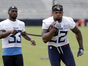 FILE - In this July 26, 2018, file photo, Tennessee Titans running back Derrick Henry (22) carries a ball tethered to a strap held by running back Dion Lewis (33) during NFL football training camp in Nashville, Tenn. Henry has a simple goal for this season as the 2015 Heisman Trophy winner chases his first starting job in the NFL: be dominant for the Titans. He won't define that by sharing any goals for yards or touchdowns, a smart move with veteran Dion Lewis also in the backfield.
