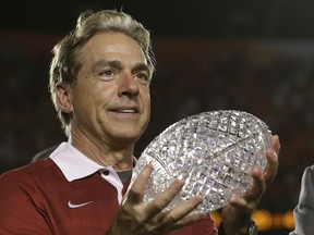 FILE - In this Jan. 7, 2013, file photo, Alabama head coach Nick Saban holds The Coaches Trophy after the BCS National Championship college football game against Notre Dame, in Miami. The decade-long chase to catch Alabama has caused patience to wear thin across the rest of the Southeastern Conference. As Nick Saban and Alabama chase their sixth national title in 10 seasons this year, five of the SEC's other 13 programs have new coaches. It represents the league's highest turnover since 1946, when the SEC had six new coaches.