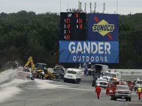 FILE - In this Aug. 19, 2018, file photo, track workers repair a section of fence after a wreck during an IndyCar auto race at Pocono Raceway in Long Pond, Pa. IndyCar driver Robert Wickens car sailed into the fence when he and Ryan Hunter-Reay made contact. Wickens had titanium rods and screws placed in his spine to stabilize a fracture associated with a spinal cord injury. He remains hospitalized in Pennsylvania.