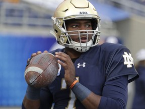 FILE - In this Monday, Jan. 1, 2018 file photo, Notre Dame quarterback Brandon Wimbush (7) looks for a receiver as he warms up before the Citrus Bowl NCAA college football game against LSU in Orlando, Fla. When No. 12 Notre Dame has the ball Saturday night, No. 14 Michigan may have the advantage. The Wolverines' experienced and fast defense has NFL-caliber players up front, at linebacker and in the secondary. The Fighting Irish, meanwhile, are relying on a quarterback who didn't complete half his passes last season.