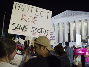 FILE - In this July 9, 2018 file photo, demonstrators holds signs as they gather in front of the Supreme Court in Washington after President Donald Trump announced Judge Brett Kavanaugh as his Supreme Court nominee. Worried by the prospect of a reconfigured court, abortion-rights advocates are intensifying efforts to ensure access to abortion for women who might be affected by a new wave of bans and restrictions.