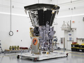 This July 6, 2018 photo made available by NASA shows the Parker Solar Probe in a clean room at Astrotech Space Operations in Titusville, Fla., after the installation of its heat shield. NASA's Parker Solar Probe will be the first spacecraft to "touch" the sun, hurtling through the sizzling solar atmosphere and coming within just 3.8 million miles (6 million kilometers) of the surface.