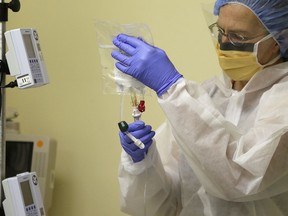 FILE - In this Monday, Nov. 13, 2017 file photo, a nurse practitioner prepares to start the first human gene editing treatment for Hunter syndrome, an inherited metabolic disease, at a hospital in Oakland, Calif. On Wednesday, Aug. 15, 2018, federal officials said that gene therapy is becoming an established form of medical care and carries no special risks that warrant special regulation, as they revised rules for vetting such experiments and products.