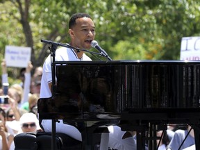 FILE - In this June 30, 2018, file photo, John Legend performs at the "Families Belong Together: Freedom for Immigrants" March in Los Angeles. Legend, Janet Jackson, The Weeknd and Shawn Mendes are among the artists slated to appear at the 2018 Global Citizen Festival. The event will take place on Sept. 29 on the Great Lawn in New York City's Central Park.