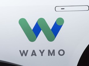 FILE - This March 27, 2018, file photo shows the Waymo logo on the of a Jaguar I-Pace vehicle, in New York. Google spinoff Waymo and Phoenix's major transit agency are partnering to test self-driving vehicles that would also boost public transportation use. Waymo announced in a blog post the start of a pilot program Tuesday, July 31, that would allow riders to hail an autonomous car to the nearest Valley Metro transit stop.