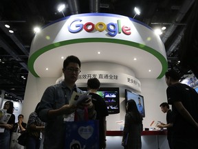 FILE - In this April 28, 2016, file photo, visitors gather at a display booth for Google at the 2016 Global Mobile Internet Conference (GMIC) in Beijing. Google is reportedly working on a mobile version of its search engine that will comply with strict censorship controls in China. The Intercept reported that the work has been ongoing since the spring of 2017 and was accelerated in December following a meeting between Google CEO Sundar Pichai and a top government official. It cited internal Google documents and unnamed people familiar with the plans.