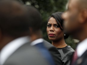 FILE - In this Feb. 28, 2017 file photo, White House Director of communications for the Office of Public Liaison Omarosa Manigault Newman stands with the of leaders of Historically Black Colleges and Universities (HBCU) outside the West Wing of the White House in Washington. The White House says former aide Omarosa Manigault Newman has "shown a complete lack of integrity" with her criticism of President Donald Trump in her new book, "Unhinged." Press secretary Sarah Huckabee Sanders said Tuesday, Aug. 14, 2018, that Trump's tweets referring to Manigault Newman as "crazed" and a "dog" reflect his "frustration" with her comments.
