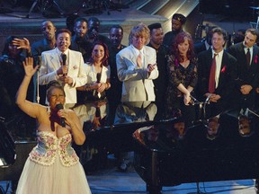 FILE - In this April 28, 1993 file photo, Aretha Franklin, foreground left, performs in the finale of "Aretha Franklin: Duets," an AIDS benefit concert for the Gay Men's Health Crisis in New York, as singers Smokey Robinson, background from left, Gloria Estefan, Rod Stewart, Bonnie Raitt and actors Dustin Hoffman and Robert De Niro look on. Franklin died Thursday, Aug. 16, 2018 at her home in Detroit.  She was 76.