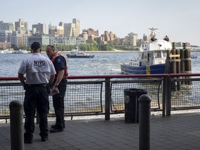 FILE - In this Aug. 5, 2018, file photo, authorities investigate the death of a baby boy who was found floating in the East River near the Brooklyn Bridge in Manhattan in New York. A Bronx father hopped a plane to Thailand after carrying his dead 7-month-old baby around New York City in a backpack and tossing the boy's body into the river and other tourist hotspots, police said Wednesday.