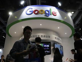 FILE - In this April 28, 2016, file photo, visitors gather at a display booth for Google at the 2016 Global Mobile Internet Conference (GMIC) in Beijing. Google employees are upset with the company's secretive plan to build a search engine that would comply with Chinese censorship, and a letter signed by more than a thousand of them calls on executives to review ethics and transparency at the company.