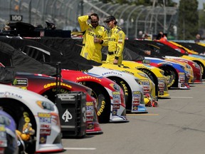 Pit crew members for Daniel Suarez talk while checking the car on pit road before a NASCAR Cup series auto race, Sunday, Aug. 5, 2018, in Watkins Glen, N.Y.