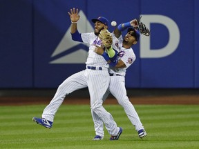 New York Mets' Amed Rosario (1) and Dominic Smith (22) collide while trying to catch a ball hit by San Francisco Giants' Brandon Crawford during the thirteenth inning of a baseball game Monday, Aug. 20, 2018, in New York. Andrew McCutchen scored on the error by Smith.