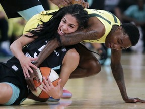 New York Liberty's Kia Nurse, left, and Seattle Storm's Natasha Howard fight for a loose ball in the first half of a WNBA basketball game, Monday, Aug. 6, 2018, in New York.