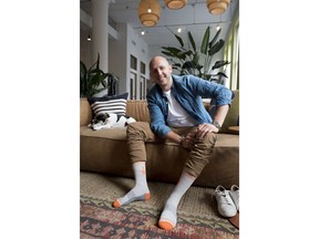 In this June 22, 2018, photo, David Health, CEO and co-founder of Bombas, poses for a photo during an interview in his New York office. Heath and his partner Randy Goldberg spent two years developing socks with features like blister tabs and arch support. Then they teamed up with shelters and nonprofit groups, and the company donates a pair for every pair it sells.