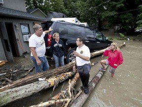 This photo provided by Governor's Press Office shows New York Governor Andrew Cuomo, second from right, as he tours flooded upstate areas of Seneca and Broome counties, Tuesday, Aug. 14, 2018. Cuomo declared a state of emergency for more than a dozen counties in the Finger Lakes region and along New York's border with Pennsylvania.