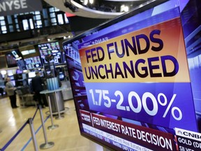A screen on the floor of the New York Stock Exchange shows the rate decision of the Federal Reserve, Wednesday, Aug. 1, 2018. The Federal Reserve is leaving its benchmark interest rate unchanged while signaling further gradual rate hikes in the months ahead as long as the economy stays healthy.