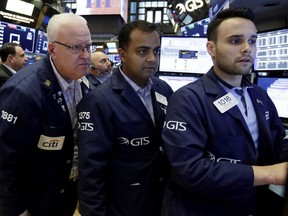 Trader Thomas Ferrigno, left, works with specialists Dilip Patel, center, and Karan Virdi on the floor of the New York Stock Exchange, Friday, Aug. 31, 2018. Stocks are opening mostly lower on Wall Street, led by declines in banks and energy companies.