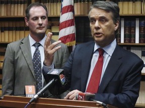 FILE - In this May 30, 2018, file photo, Kansas Gov. Jeff Colyer, right, answers a question from reporters as Lt. Gov. Tracey Mann, left, listens during a news conference in Topeka, Kan. Colyer and immigration hardliner Kris Kobach were virtually tied atop a seven-candidate field with nearly two-thirds of the precincts counted in the primary, late Tuesday, Aug. 7, 2018.