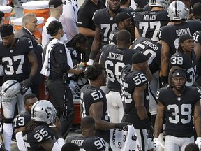 Oakland Raiders running back Marshawn Lynch, center left, sits near the sideline just before the national anthem at an NFL preseason football game between the Raiders and the Detroit Lions in Oakland, Calif., Friday, Aug. 10, 2018. Lynch remained seated for the anthem.