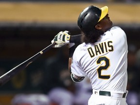 Oakland Athletics' Khris Davis swings on a pitch from Texas Rangers' Bartolo Colon in the fifth inning of a baseball game, Monday, Aug. 20, 2018, in Oakland, Calif. Davis' jersey is signed by Anthony Slocumb, a child from the Make A Wish Foundation, seen on Davis' left shoulder. Davis hit his 37th home run of the season wearing the signed jersey.