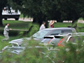 People with their hands up come out amid reports of an active shooter at Wright-Patterson Air Force base in Ohio on Thursday, Aug. 2, 2018.