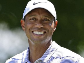 Tiger Woods smiles on the tee box of the fifth hole during the third round of the Bridgestone Invitational golf tournament at Firestone Country Club, Saturday, Aug. 4, 2018, in Akron, Ohio.
