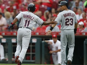 Cleveland Indians' Jose Ramirez (11) and Michael Brantley (23) celebrate after scoring on Yonder Alonso single off Cincinnati Reds starting pitcher Sal Romano during the first inning of a baseball game, Tuesday, Aug. 14, 2018, in Cincinnati.