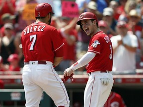 Cincinnati Reds' Eugenio Suarez (7) and Scooter Gennett, right, celebrate Suarez's two-run home run off San Francisco Giants starting pitcher Andrew Suarez during the third inning of a baseball game, Sunday, Aug. 19, 2018, in Cincinnati.