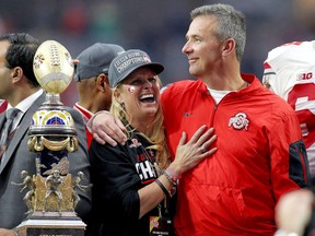In this Jan. 1, 2016, file photo, Ohio State head coach Urban Meyer hugs his wife, Shelley, after their 44-28 win over Notre Dame in the Fiesta Bowl NCAA college football game, in Glendale, Ariz. Ohio State placed Meyer on paid administrative leave Wednesday, Aug. 1, 2018, while it investigates claims that his wife knew about allegations of abuse against former Buckeyes assistant Zach Smith, who was fired last week.