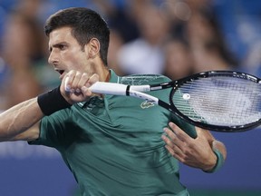 Novak Djokovic, of Serbia, returns to Steve Johnson in the first round at the Western & Southern Open, Monday, Aug. 13, 2018, in Mason, Ohio.