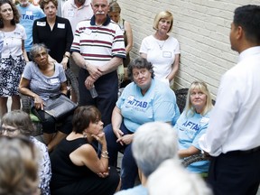 Audience members listen as Hamilton County Clerk of Courts Aftab Pureval, right, speaks at a fundraising event for his 1st House District campaign challenge to veteran Republican Rep. Steve Chabot at a supporters home, Friday, June 15, 2018, in Maineville, Ohio. The Democratic candidate for Congress in southwest Ohio jokes that besides already going against the electoral odds, he's a "brown dude with a funny name." But 35-year-old Aftab Pureval is attracting national attention as tries to unseat veteran Republican Rep. Steve Chabot, part of the Cincinnati-area political landscape for three decades.