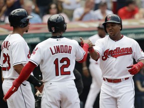 Cleveland Indians' Jose Ramirez, right, is congratulated by Francisco Lindor and Michael Brantley after hitting a three-run home run in the first inning of a baseball game against the Los Angeles Angels, Sunday, Aug. 5, 2018, in Cleveland.